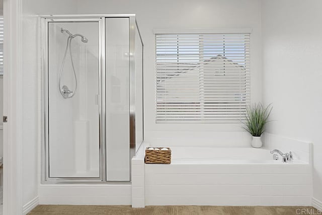 bathroom with a stall shower and a bath