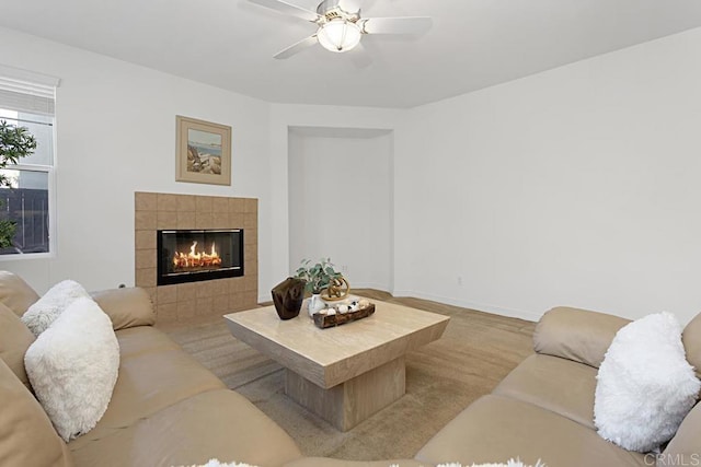 living room with baseboards, ceiling fan, and a fireplace