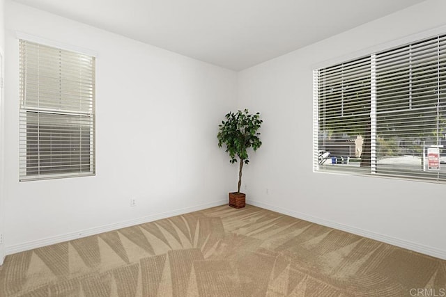 empty room featuring baseboards and carpet flooring