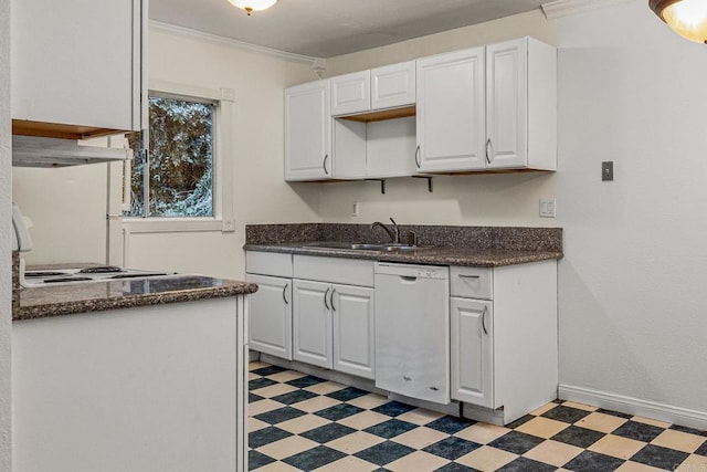 kitchen with dark countertops, a sink, light floors, and white dishwasher