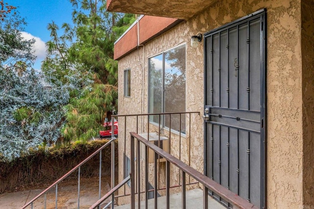 doorway to property with stucco siding and central AC