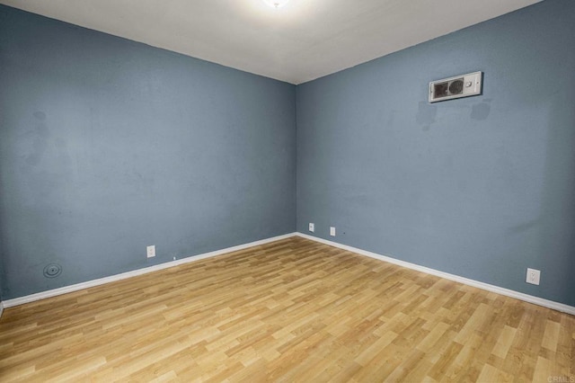 spare room featuring baseboards and wood finished floors