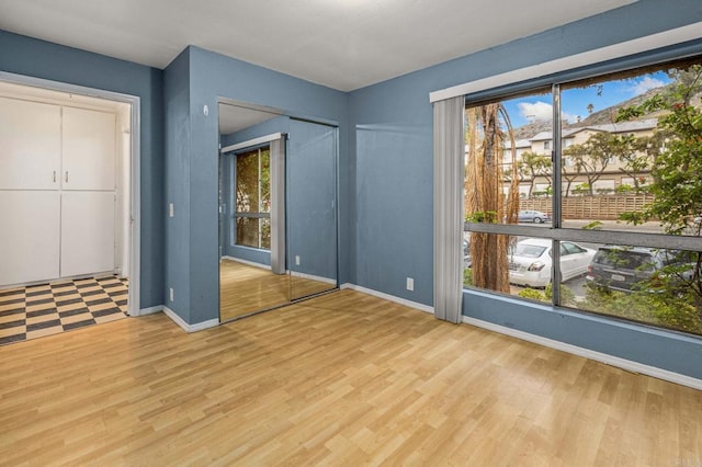 unfurnished bedroom with wood finished floors and baseboards