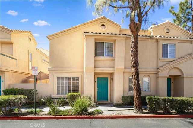 view of front of property featuring a tiled roof and stucco siding