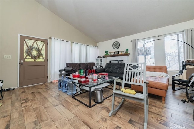 living room featuring high vaulted ceiling and light wood-style floors