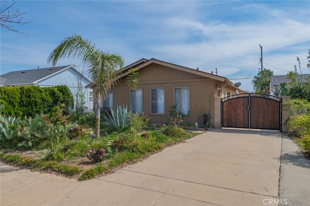 view of front of home with concrete driveway and a gate