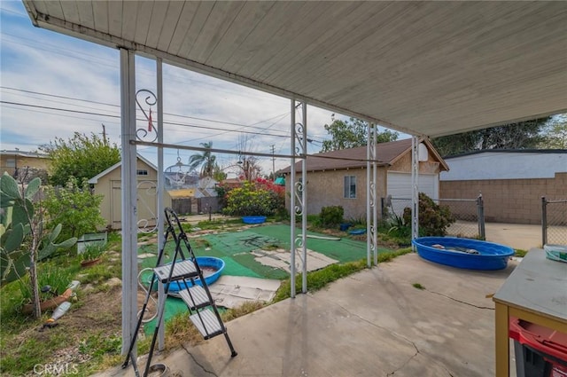 view of patio / terrace featuring an outdoor structure, a fenced backyard, and a shed