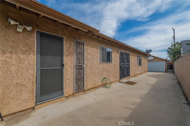 exterior space featuring an outbuilding, fence, and a garage