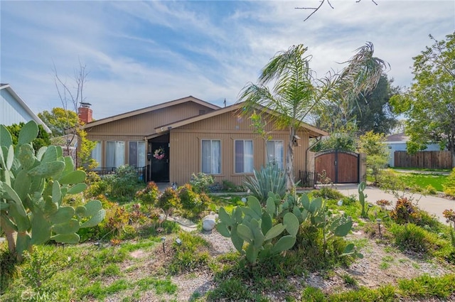 view of front of house featuring concrete driveway, a gate, and fence