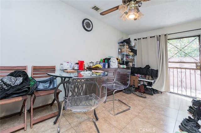 tiled dining room with visible vents, a ceiling fan, and vaulted ceiling