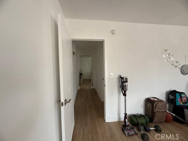 hallway with wood finished floors and baseboards