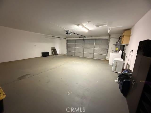 garage featuring strapped water heater and a garage door opener