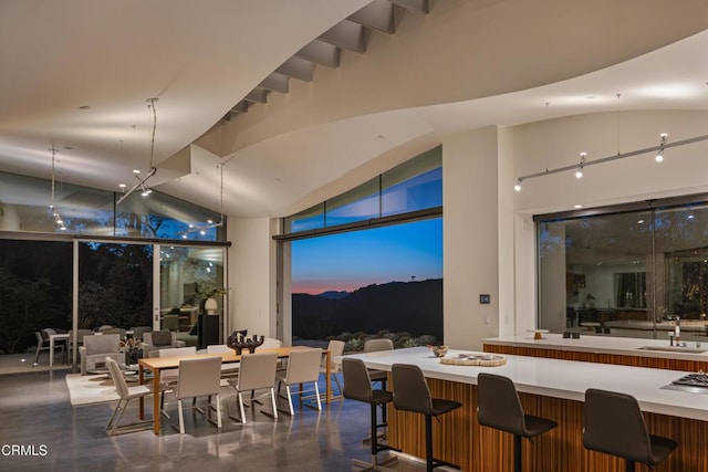 dining area with finished concrete flooring and high vaulted ceiling