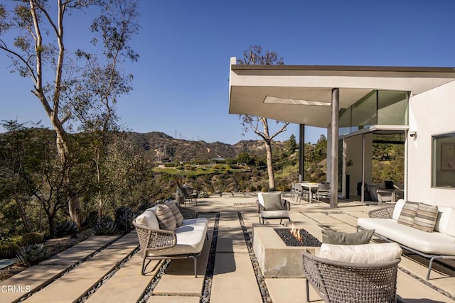 view of patio / terrace featuring a mountain view and an outdoor living space with a fire pit