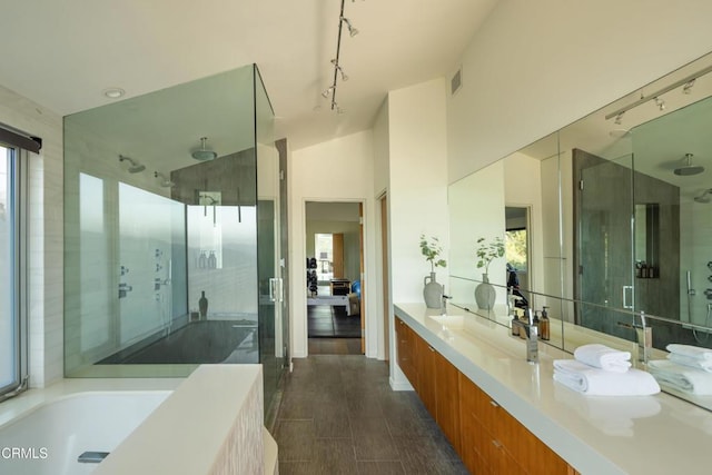 bathroom featuring vanity, visible vents, lofted ceiling, a stall shower, and a bath