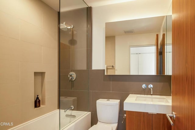 full bathroom with toilet, vanity, decorative backsplash, bathing tub / shower combination, and tile walls