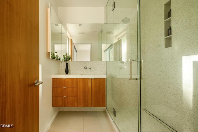 bathroom with vanity, backsplash, a shower stall, and tile patterned flooring