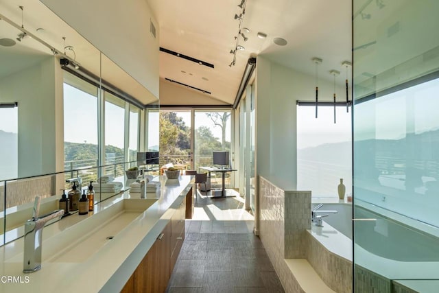 full bathroom featuring visible vents, track lighting, a garden tub, vaulted ceiling, and vanity