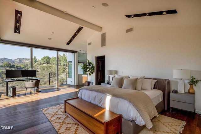 bedroom featuring access to exterior, visible vents, expansive windows, and hardwood / wood-style flooring