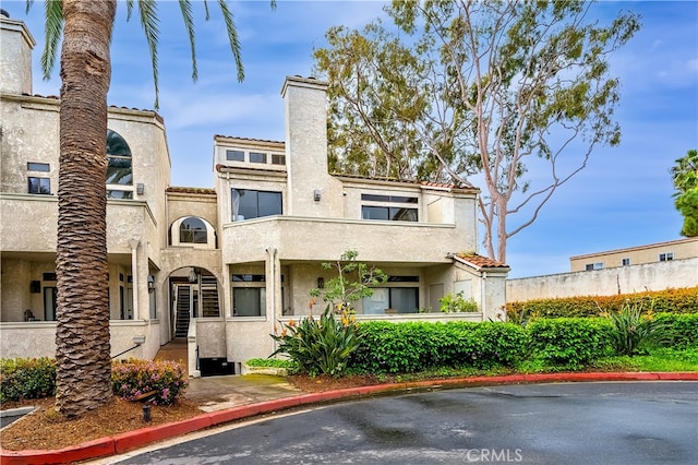 view of front of property with a chimney and stucco siding