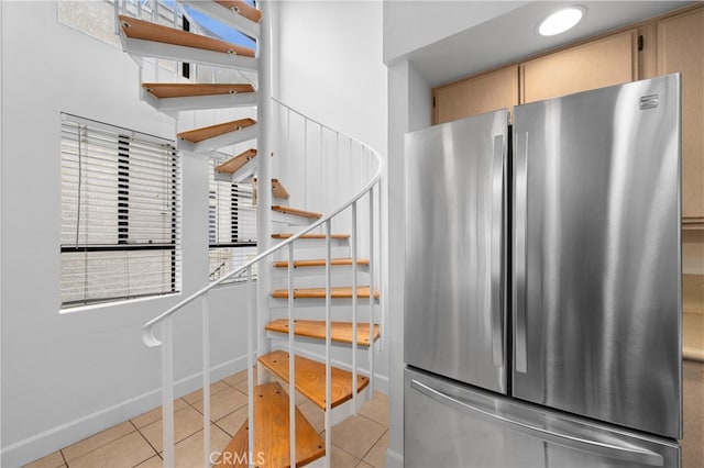 stairs with tile patterned floors and baseboards