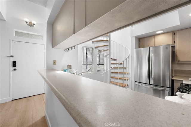 kitchen with light wood-style flooring, light countertops, and freestanding refrigerator