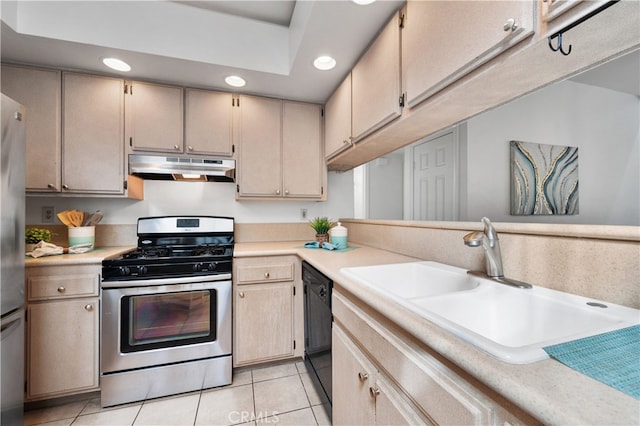 kitchen featuring under cabinet range hood, appliances with stainless steel finishes, light countertops, and a sink