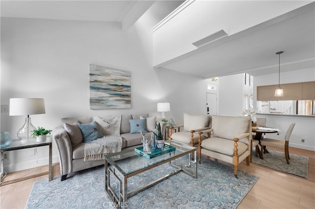 living room with baseboards, wood finished floors, and a towering ceiling