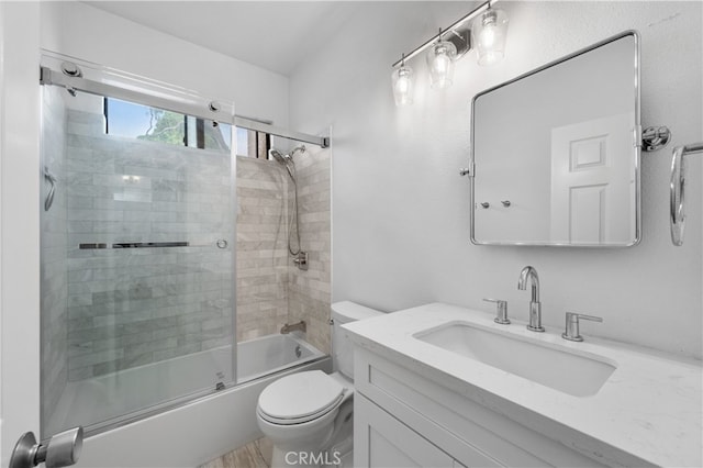 bathroom featuring vanity, toilet, and shower / bath combination with glass door