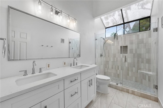 bathroom with a sink, toilet, double vanity, and a shower stall