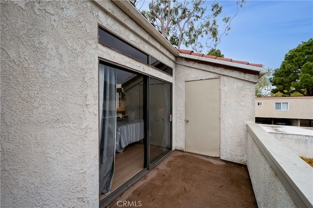 exterior space with stucco siding and a balcony