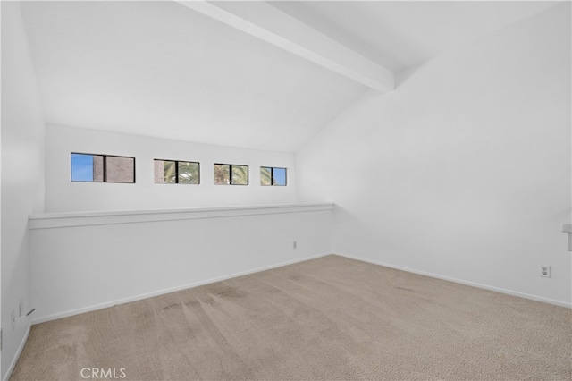 spare room featuring carpet flooring, lofted ceiling with beams, and baseboards