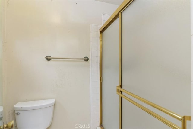 full bath featuring a shower stall and toilet