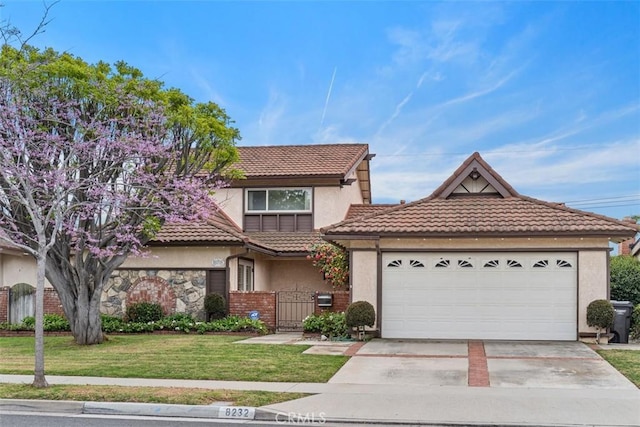 view of front of home featuring a tiled roof, a front yard, stucco siding, a garage, and a gate