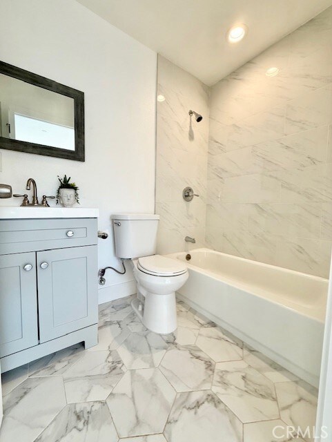 bathroom featuring vanity, toilet, baseboards, shower / tub combination, and recessed lighting