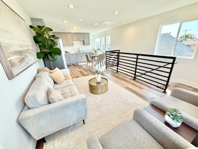 living room with baseboards, recessed lighting, and light wood-style flooring