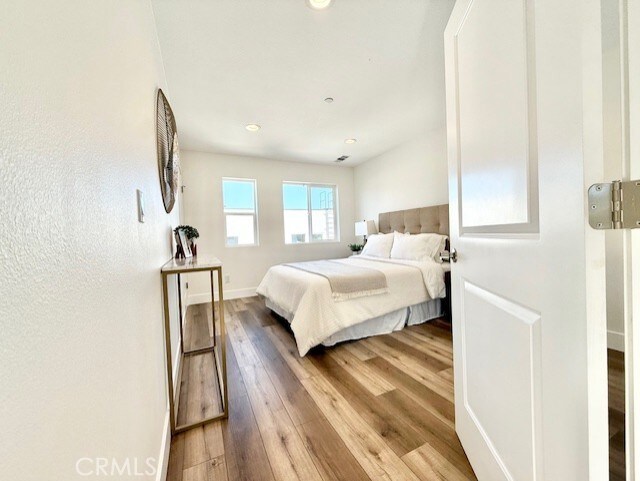 bedroom with baseboards, recessed lighting, and wood finished floors