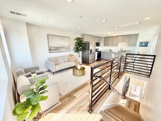 living area featuring recessed lighting, light wood-type flooring, and visible vents