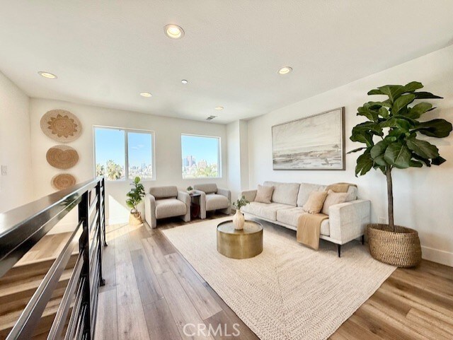 living room with recessed lighting, baseboards, and wood finished floors