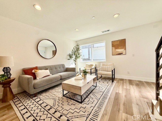 living area with recessed lighting, baseboards, visible vents, and light wood-type flooring