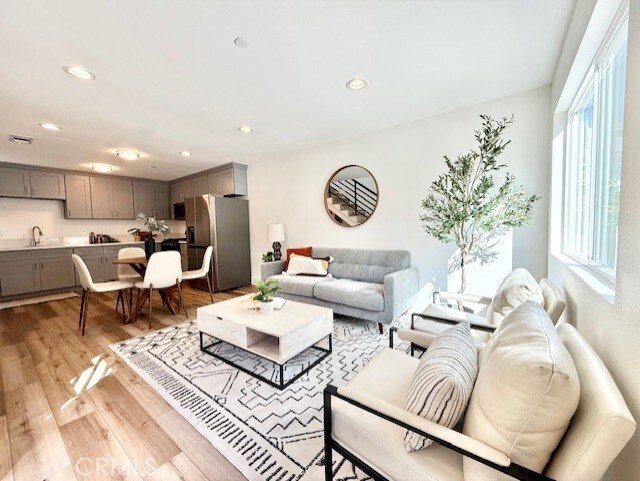 living area featuring recessed lighting, a healthy amount of sunlight, and light wood-style floors