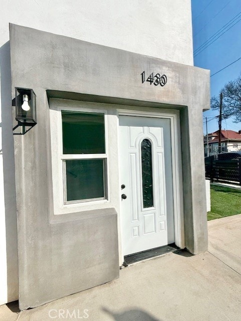 entrance to property featuring stucco siding