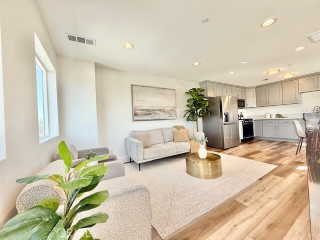 living room featuring visible vents, recessed lighting, and light wood-style flooring