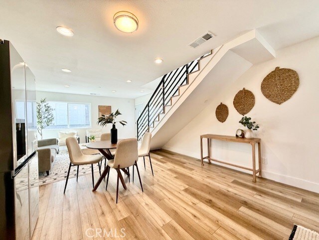 dining room featuring visible vents, recessed lighting, light wood finished floors, and stairway