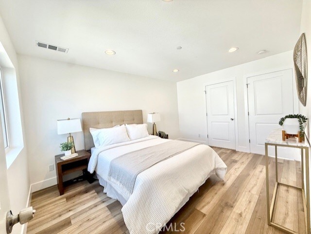 bedroom featuring visible vents, recessed lighting, light wood-style flooring, and baseboards