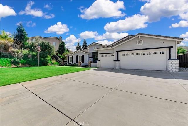 view of front of house with brick siding, driveway, a front yard, and a garage