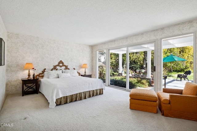 bedroom with wallpapered walls, access to exterior, carpet, and a textured ceiling