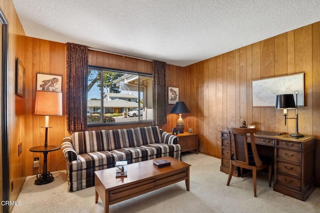 living area featuring wooden walls, light colored carpet, and a textured ceiling