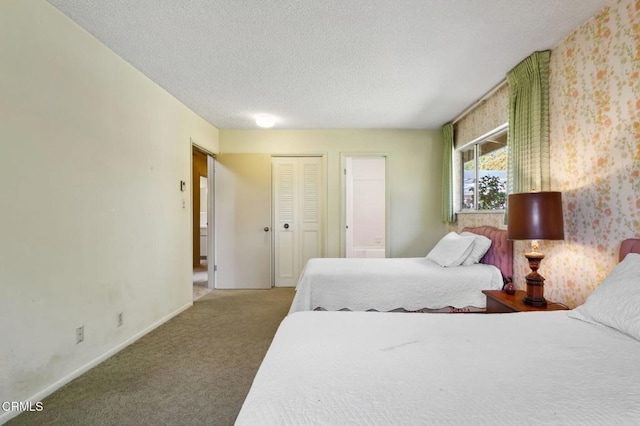 bedroom featuring baseboards, carpet floors, a textured ceiling, and a closet