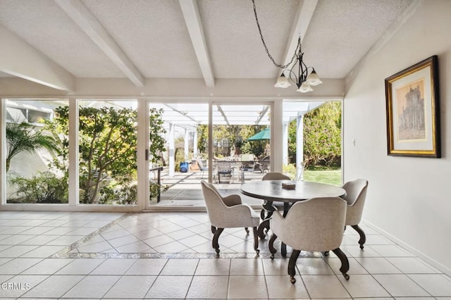 sunroom featuring a notable chandelier and beamed ceiling